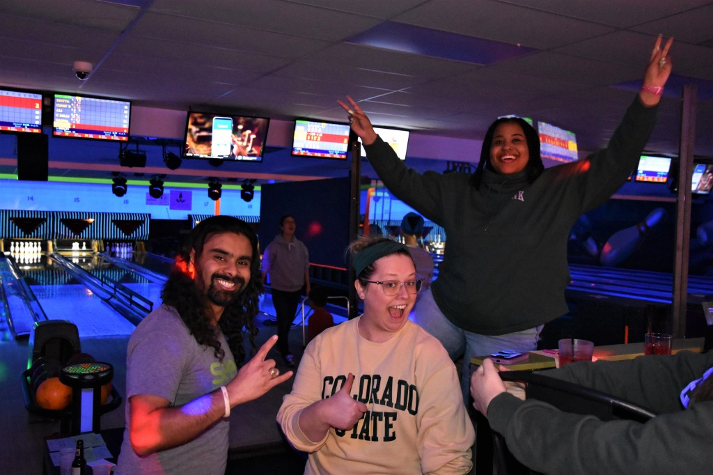 Students looking enthusiastic in a bowling alley
