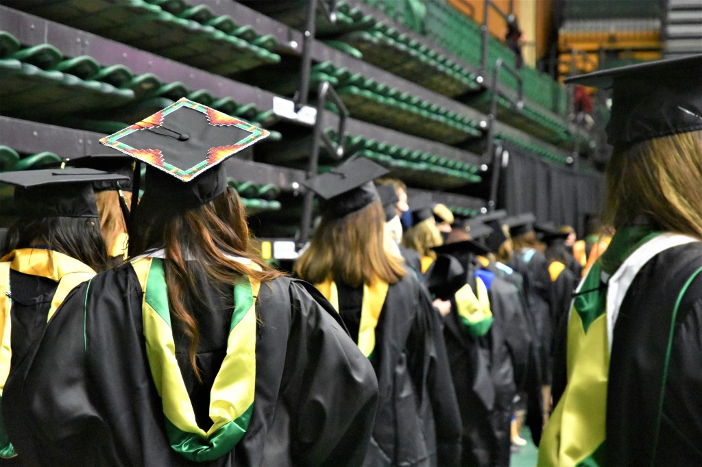 Master's student at commencement with decorated hat